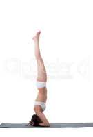 Side view of slender girl doing handstand