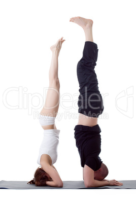 Pair of flexible yoga trainers doing handstand