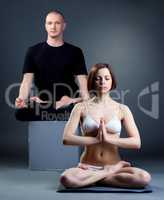 Meditating yoga trainers posing in studio