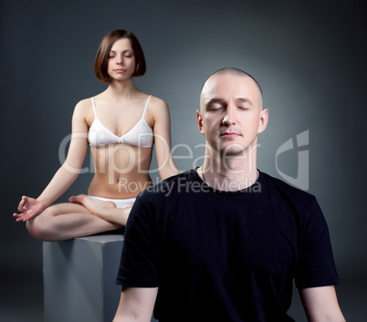 Yoga studio. Meditating trainers, on gray backdrop