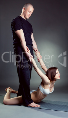 Image of experienced instructor helps girl in yoga