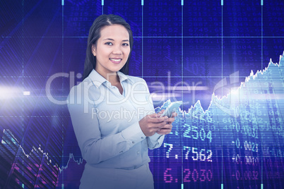 Composite image of smiling businesswoman using her smartphone