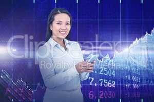 Composite image of smiling businesswoman using her smartphone