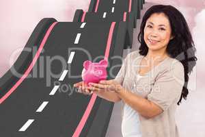 Composite image of happy woman holding a piggy bank