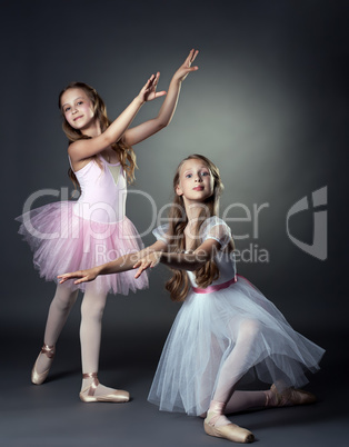 Emotional young ballerinas posing in studio
