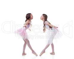 Amusing ballerinas posing looking at each other