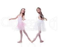 Cute sisters-ballerinas isolated on white backdrop