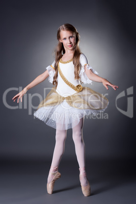 Cute young ballerina posing in elegant dress