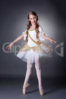Cute young ballerina posing in elegant dress