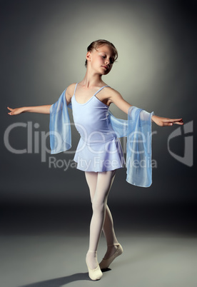 Charming little dancer posing on gray background