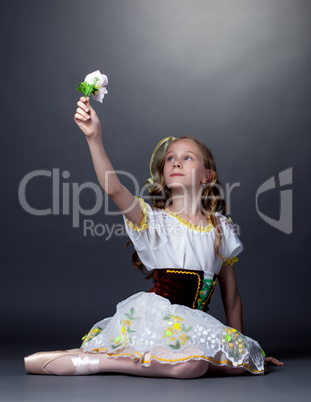 Emotional ballet dancer posing looking at flower