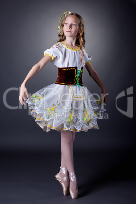 Charming young ballerina dancing in folk costume