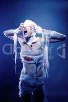 Portrait of screaming mummy pulling her bandages