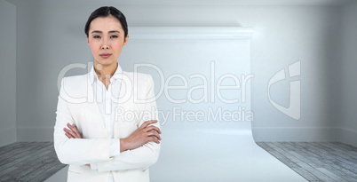 Composite image of serious businesswoman with crossed arms