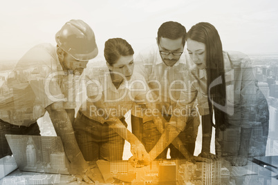 Composite image of architecture team working together at desk