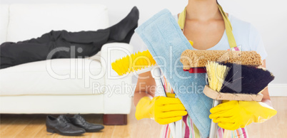 Composite image of woman holding brushes and mops