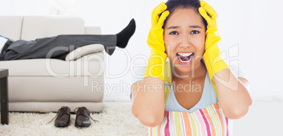 Composite image of distressed woman wearing apron and rubber glo