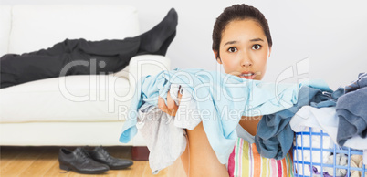 Composite image of frowning woman taking out dirty laundry