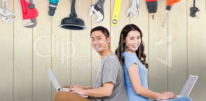 Composite image of portrait of young happy couple using laptop w