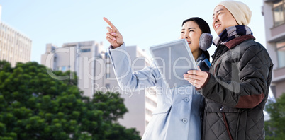 Composite image of couple looking away while holding digital tab