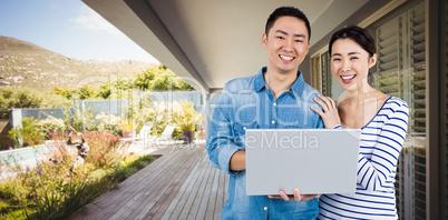 Composite image of portrait of couple using laptop