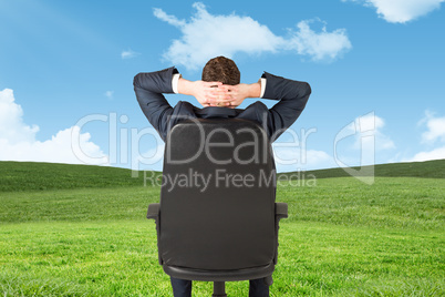 Composite image of businessman sitting in swivel chair