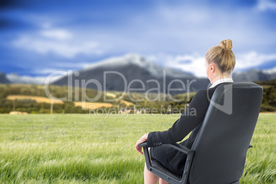 Composite image of businesswoman sitting on swivel chair in blac