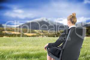 Composite image of businesswoman sitting on swivel chair in blac