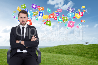 Composite image of serious businessman sitting with arms crossed