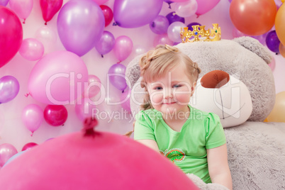 Neat little girl posing in studio with balloons