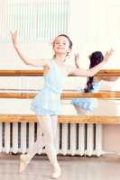 Artistic girl posing at camera in ballet class