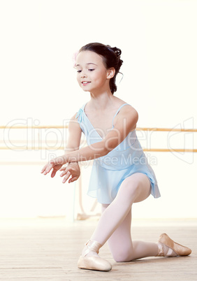 Little dancer doing exercises in ballet studio