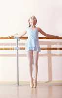 Petite ballerina doing exercises in dance class