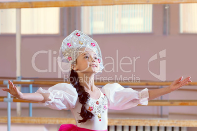 Artistic young ballerina posing in Russian costume