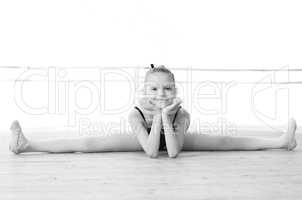 Black and white photo. Cute ballerina doing split