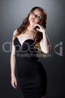 Languid red-haired girl posing in skin-tight dress