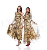 Charming women posing in dresses from same cloth