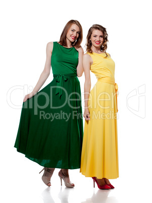 Smiling girls posing in stylish colorful dresses