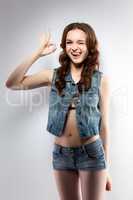 Image of cheerful young girl shows gesture OK