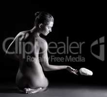 Spiritual nude woman telekinetically moving stone