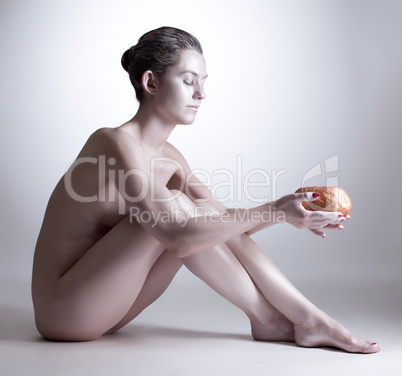 Skinny woman with silver skin posing holding stone