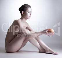 Skinny woman with silver skin posing holding stone