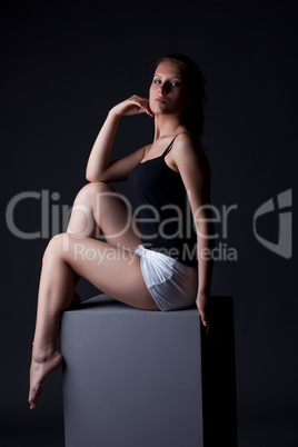 Image of sporty young girl posing sitting on cube