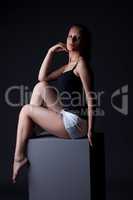 Image of sporty young girl posing sitting on cube