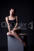 Studio shot of sexy young model sitting on cube