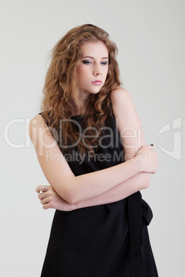 Studio shot of dreamy young model in black dress