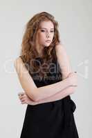 Studio shot of dreamy young model in black dress