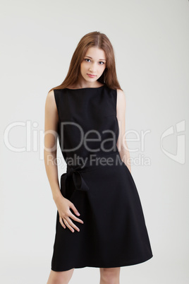 Charming young brunette posing in black dress