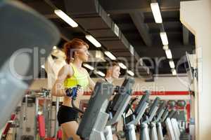 Lovely girl posing on treadmill in gym