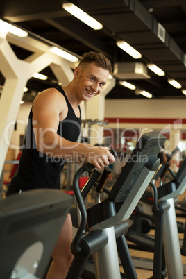 Cheerful runner posing at camera in gym